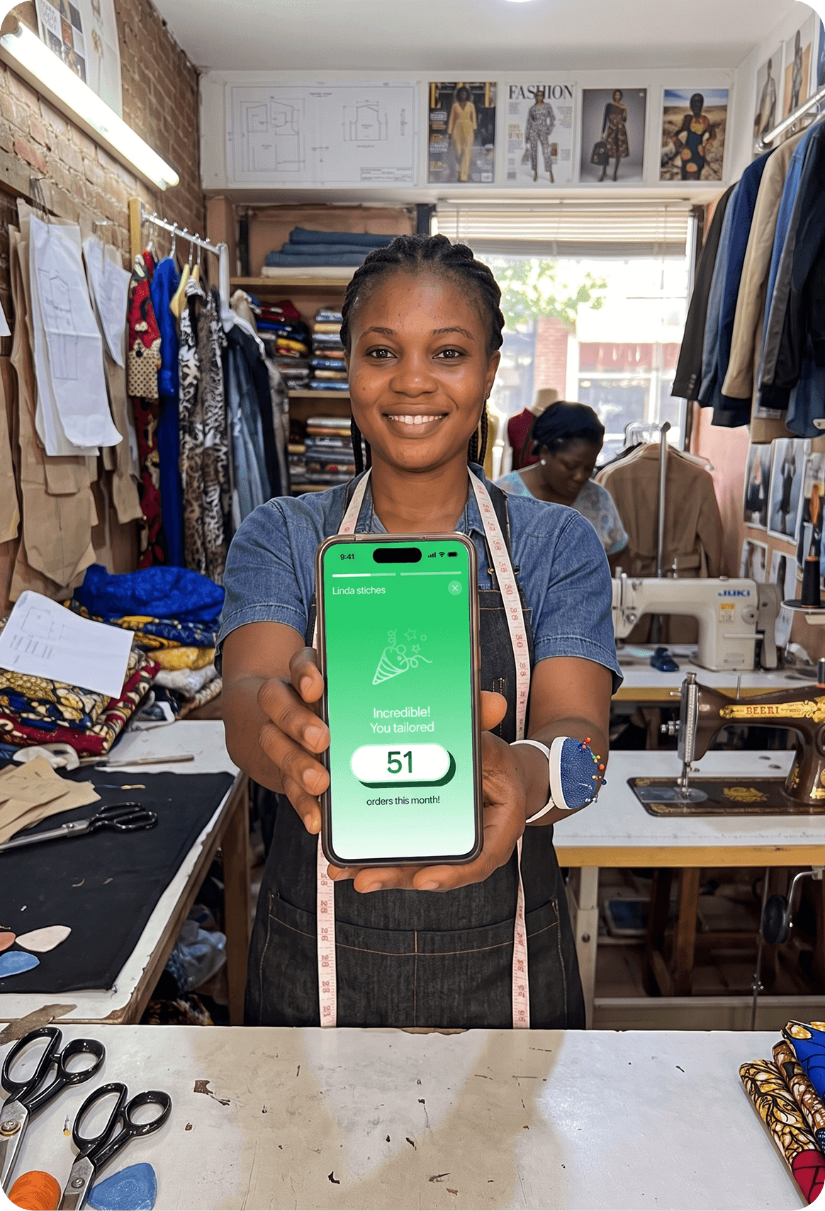 Obyọma atelier artisan holding smartphone with revenue dashboard